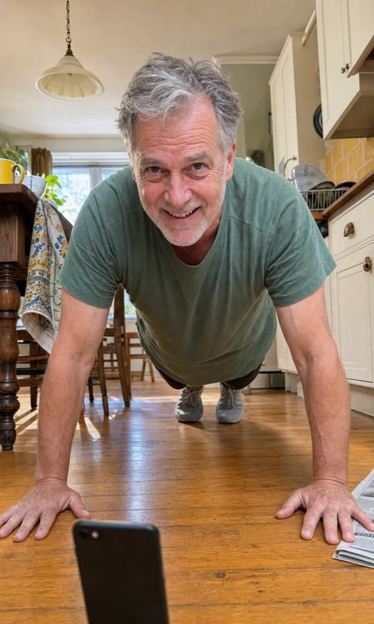 Theo doing push-ups in his kitchen with his phone propped on the floor